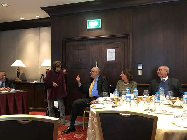 Club members talking and laughing around a table at a hotel breakfast meeting